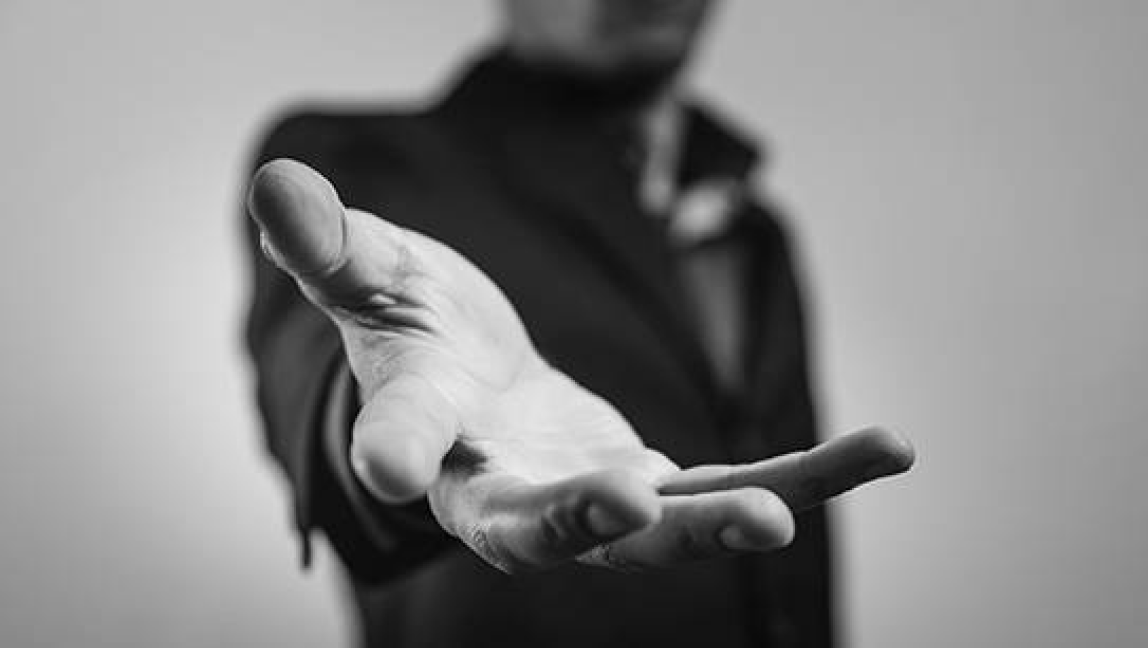 Black and white photo of person with hand outreached